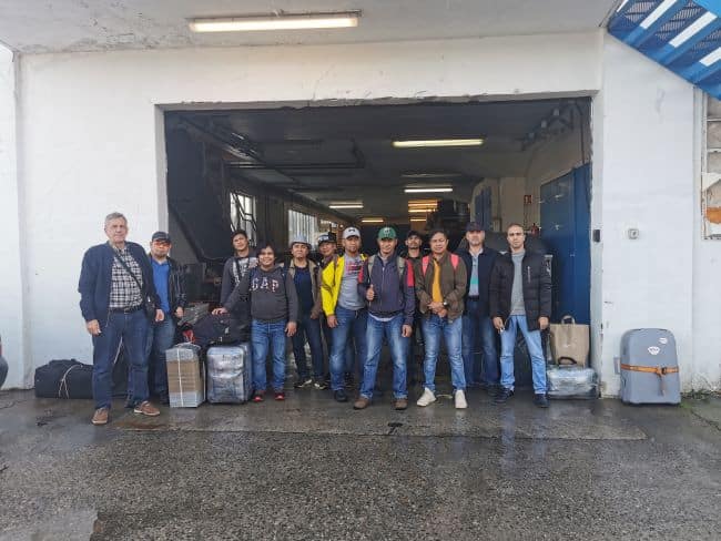 The crew of the MV Diavlos Force stop for a group photo as they leave the vessel on their way home